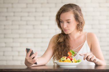 Yanında salata kasesi ile neşeli duruşlar güzel genç kadın