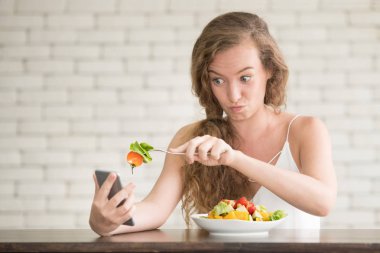 Yanında salata kasesi ile neşeli duruşlar güzel genç kadın