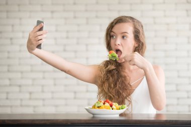 Yanında salata kasesi ile neşeli duruşlar güzel genç kadın