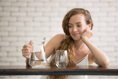 Sürahi ve bardak içme suyu yan neşeli duruşlar güzel genç kadın