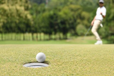 Adam golfçü bir golf yeşil bir golf topu sonra tezahürat