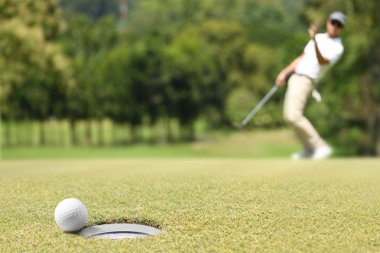 Adam golfçü bir golf yeşil bir golf topu sonra tezahürat