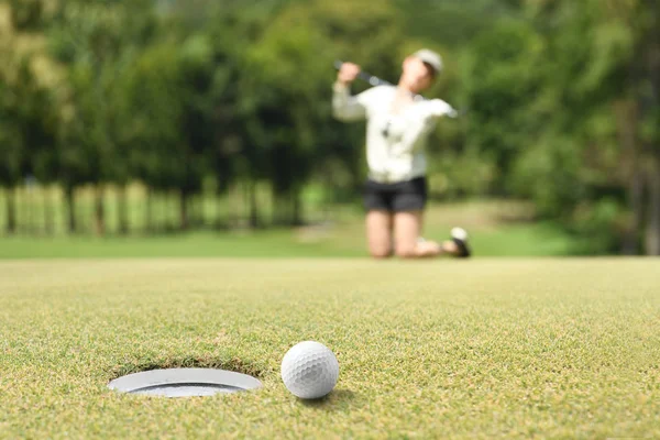 女性ゴルファー ツリーフォルダーのゴルフ ボールは穴を逃した後に失望感 — ストック写真