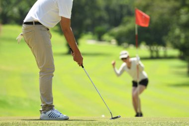  Erkek ve kadın güzel doğal golf sahasında golf oynamak