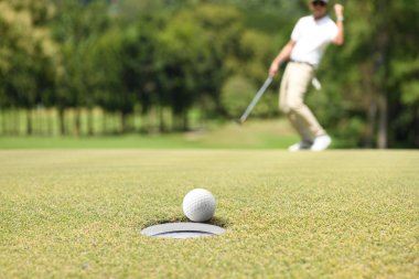 Adam golfçü bir golf yeşil bir golf topu sonra tezahürat