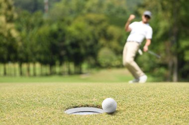 Adam golfçü bir golf yeşil bir golf topu sonra tezahürat