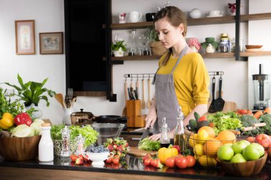 Genç kadında sağlıklı meyve ve sebzeler sağlıklı yemek ve salata için hazırlık bir mutfak