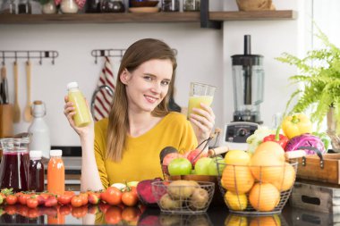 Genç kadında sağlıklı meyve ve sebze ve meyve suyu ile bir mutfak