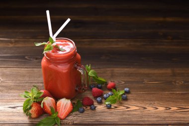 Karışık berry yüzlü cam ahşap zemin üzerine dilimlenmiş çilek ile