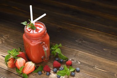 Karışık berry yüzlü cam ahşap zemin üzerine dilimlenmiş çilek ile