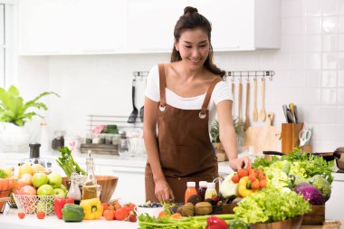 Asyalı kadın mutfakta sebze kesme ve sağlıklı yemek ve salata hazırlık