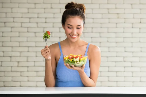 Asian woman in joyful postures with hand holding salad