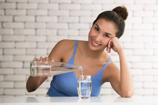 Wanita Asia Menuangkan Air Dari Botol Gelas Dalam Ruangan — Stok Foto