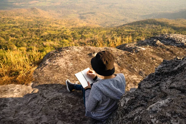 Μια Γυναίκα Κάθεται Ανάγνωσης Και Γραφής Κοιτάζοντας Όμορφο Φυσικό Άποψη — Φωτογραφία Αρχείου
