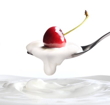 Üzerine bir kaşık yoğurt yoğurt beyaz arka plan üzerinde izole yukarıda üst asılı üzerinde taze kiraz ile