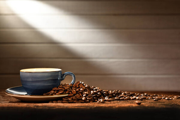 Coffee cup and coffee beans on old wooden background