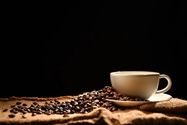 黑色背景的咖啡杯和咖啡豆 — 图库照片