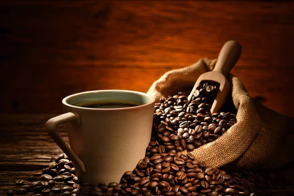 旧木制背景下的咖啡和咖啡豆杯 — 图库照片