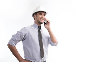 Asya mühendis veya mimar gülümseyen ve beyaz arka plan üzerinde izole bir cep telefonu kullanarak portresi