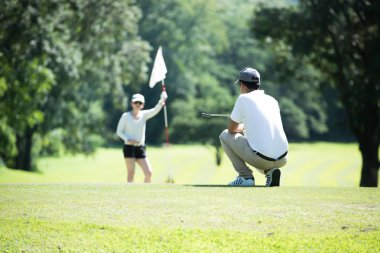 Erkek ve kadın güzel doğal golf sahasında golf oynamak