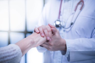 Tıbbi doktor güven verici hasta hastane ortamında hasta elini tutarak