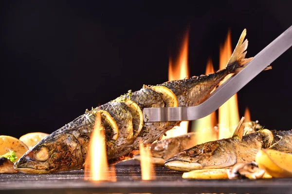 燃えるグリルの上に様々な野菜を使った焼き魚 — ストック写真