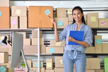 Genç Asyalı kadın girişimci / İş sahibi online alışveriş için evde çalışan ve paket ürün hazırlanması 