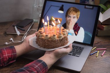 Asyalı orta yaşlı kadın, sosyal uzaklık sırasında evdeki video görüşmesiyle sanal doğum gününü kutlarken mutlu ve seviliyor.