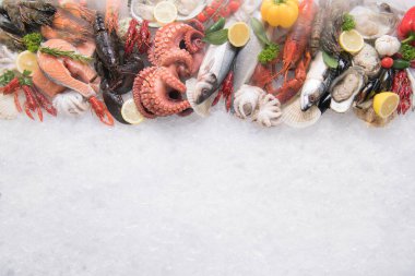 Kuru buz dumanı ve fotokopi ile buzda taze balık ve deniz ürünlerinin üst düzey görüntüsü.