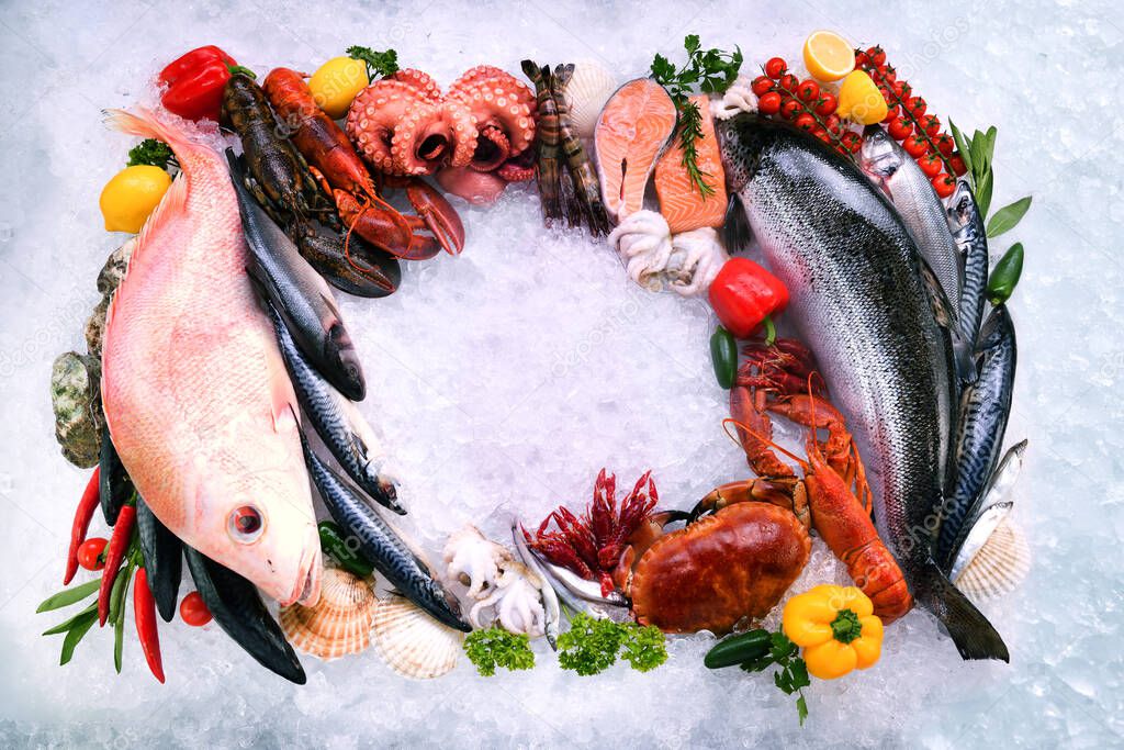 Top view of variety of fresh fish and seafood with copy space on ice