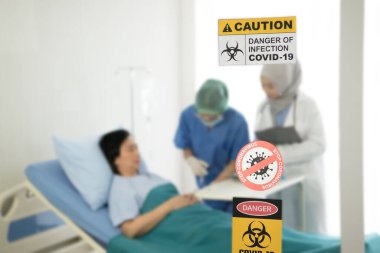 Korumalı vites takan ve hastane odasında hasta tedavi eden Asyalı kadın doktor.