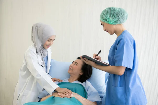 Asyalı Kadın Doktorlar Hastane Odasında Kadın Hastaları Muayene Edip Tedavi — Stok fotoğraf