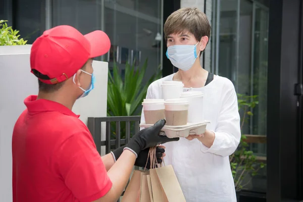 Azjatycki Dostawca Masce Rękawiczkach Czerwonym Mundurze Dostarczający Odbiorcy Jedzenie Napoje — Zdjęcie stockowe