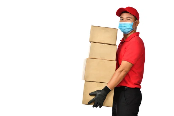 Covid 爆发期间 亚洲派递员戴着口罩和手套 身穿红色制服 运送白色背景的包裹 — 图库照片