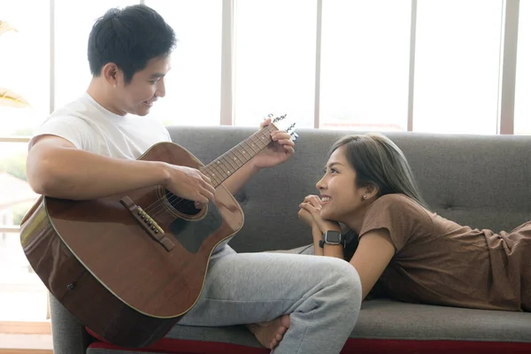 Joven Pareja Asiática Sentarse Sofá Tocar Guitarra Apartamento —  Fotos de Stock