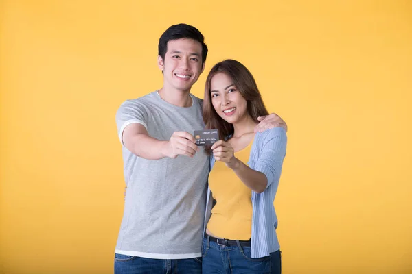 Joven Pareja Asiática Mostrando Tarjeta Crédito Aislada Sobre Fondo Amarillo —  Fotos de Stock