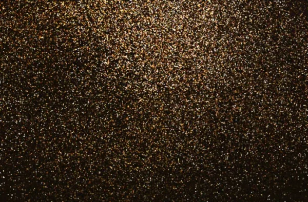 Golden powder abstract pattern on dark low background. Sanded texture.