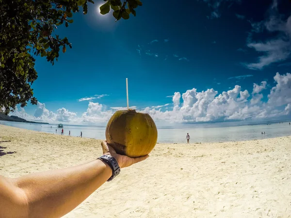 明るい晴れた日にビーチでココナッツの果物を保持する — ストック写真