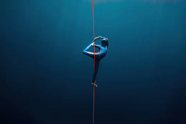 Bir serbest dalgıç ve yogi su altında yoga pozu veriyorlar.