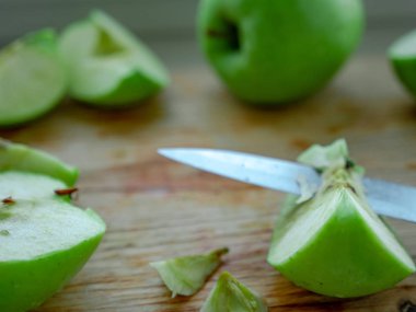 Elma çekirdeklerini kesip ahşap bir C üzerinde yeşil elmalar hazırlamak.
