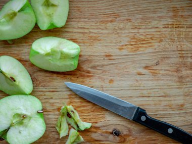 Tahta kesme tahtasındaki yeşil elma ve bıçak..