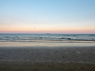 Ufukta gezinen uzun kargo gemisiyle sakin, pürüzsüz, mavi Akdeniz üzerinde alçaktan uçan uçak. Kıbrıs Rum Kesimi 'nin Larnaka havaalanına inmeye hazırlanıyor..
