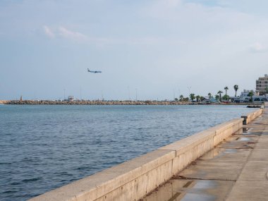 Kıbrıs Rum Kesimi 'nin Larnaka havaalanına inmeye hazırlanan uçak. Sakin, mavi Akdeniz 'in üzerinde dalgalı dalgalar ve gezinti güvertesiyle alçaktan uçuyor..