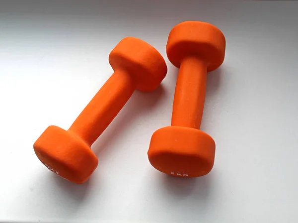 Twee Oranje Dumbbells Van Elk Een Een Grijze Achtergrond — Stockfoto