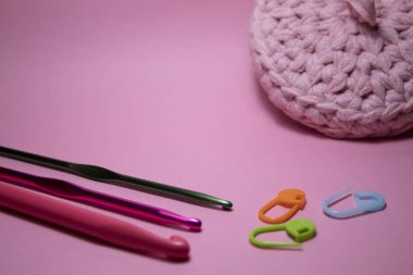 Tığ işi kancalar. Pembe arka planda. Mesajlaşmak için bir yer var. Boşluğu kopyala.