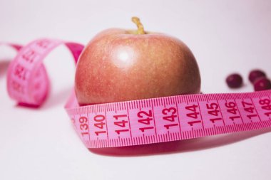 Etrafında mezura olan kırmızı bir elma. Yan görüş. Diyet konsepti. Sağlık kavramı.