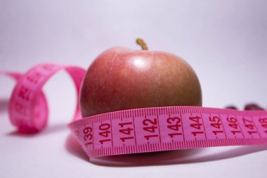 Etrafında mezura olan kırmızı bir elma. Yan görüş. Diyet konsepti. Sağlık kavramı.