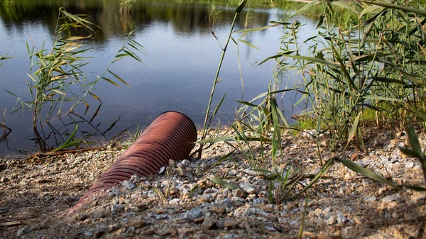 Waste pipe near the lake. Close-up.