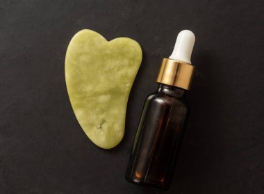 Gua sha aleti ve cam şişe serumu. Gua sha concepli masaj