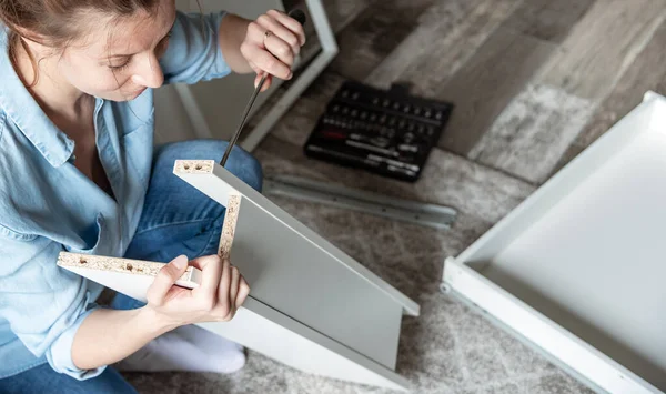 Young caucasian woman repairing furniture at home